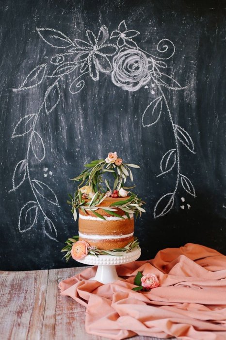 Свадебный торт с открытыми коржами, украшенный цветами и зеленью