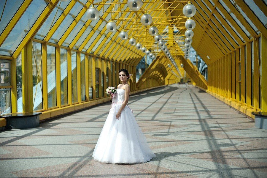 Фотосессия невесты на мосту среди желтых колонн
